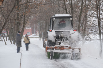 snow-removal tractor cleans alley in the park