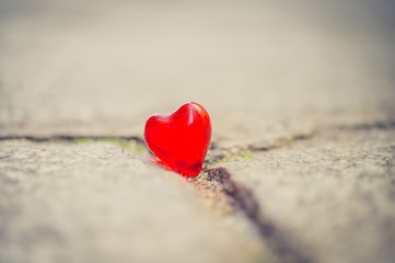 Fototapeta premium macro red heart on a vintage cream wall