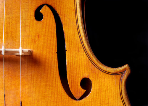 Violin music, closeup of violin f hole isolated on black