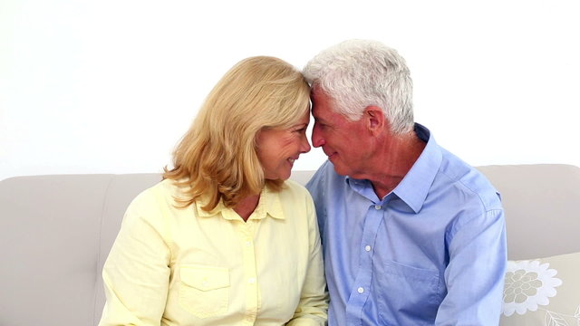 Smiling retired couple being affectionate on the couch