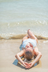 Closeup on young woman in swimsuit laying on sea shore