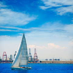 Valencia city port with sailboat and cranes in background