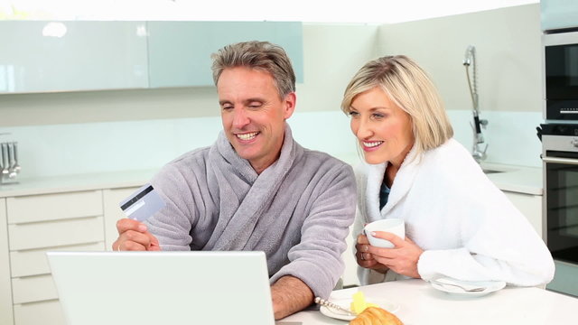 Mature couple shopping online at breakfast
