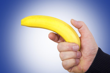 Hand holds banana as a gun