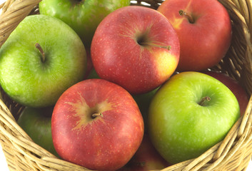 Ripe color apples in brown wicker basket isolated
