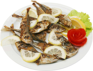 Grilled tasty fish on BBQ with lemons and vegetables 