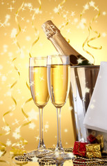 Champagne bottle in bucket with ice and glasses,