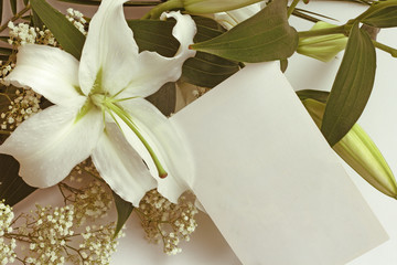 White lily flowers and post card