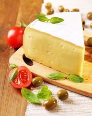 Tasty Camembert cheese with tomatoes, olives and basil,