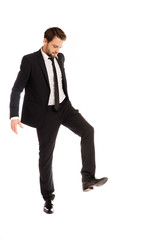 Businessman raising his foot to stamp on something