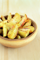 Fried potato wedges on wooden table