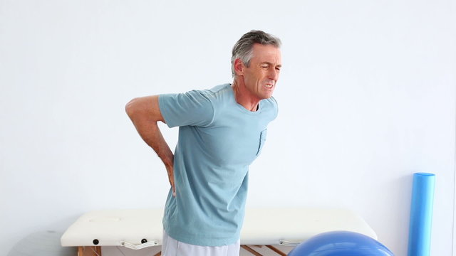 Mature patient rubbing his painful back
