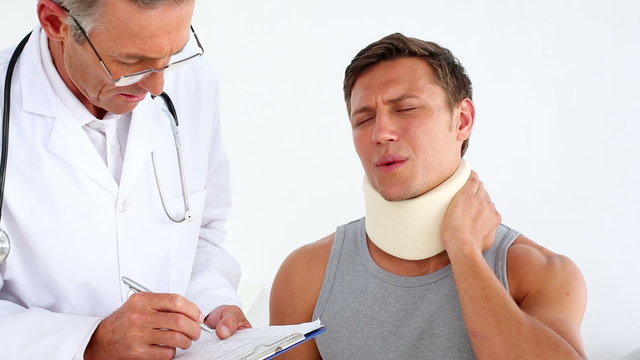 Doctor checking sportsman in neck brace