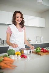 Obraz na płótnie Canvas Portrait of smiling woman preparing food in kitchen