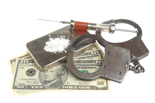 Drugs, syringe with blood, handcuffs and money isolated