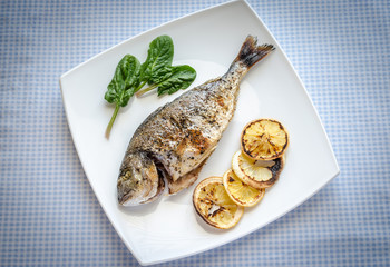 Grilled dorada fish with lemon and spinach