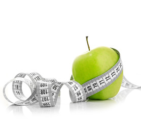 Measuring tape wrapped around a green apple - 60846814