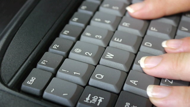 Close up woman's fingers typing on keyboard