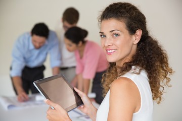 Confident businesswoman holding digital tablet