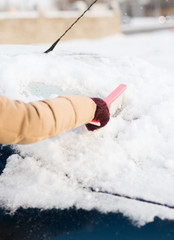woman cleaning snow from car back window