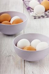 Fototapeta na wymiar White and brown eggs in a lilac ceramic cup