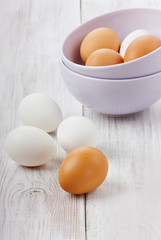 White and brown eggs in a lilac ceramic cup