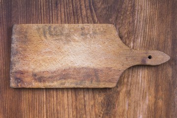 old wooden cutting board on a wooden background