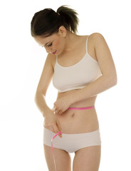 Obraz premium Slender young woman measuring her waist