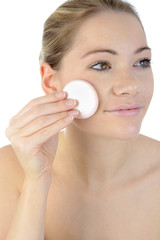 Frau reinigt Gesicht mit Watte-Pad