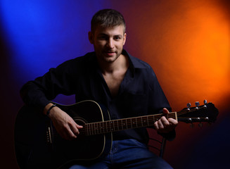 Obraz premium Young musician playing acoustic guitar and singing,