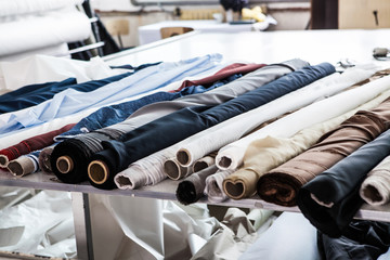rolls of textile material on a table in a factory