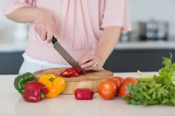 Fotobehang Mid section of woman chopping vegetables © WavebreakmediaMicro
