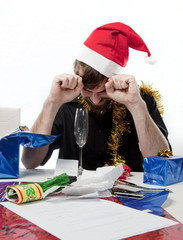 Man in Santa Claus hat loooking depressed about money