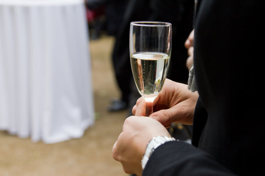 Man in suit holding glass of sekt