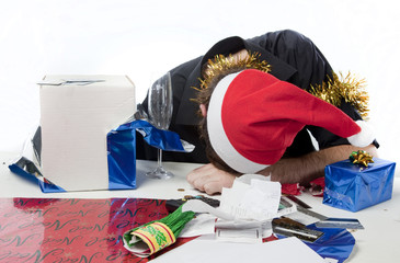 Man in Santa Claus hat depressed about his finances.