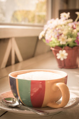 Cup of milk tea with flowers, retro filter effect
