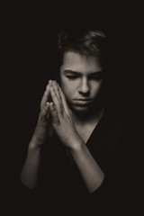 Portrait of pensive teenager on black background
