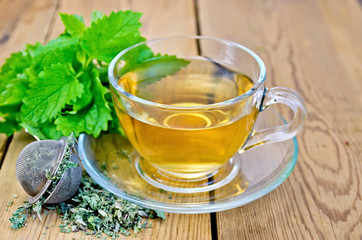 Herbal tea with melissa in a cup and strainer