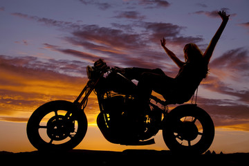 Fototapeta na wymiar Silhouette woman on a motorcycle arms in air