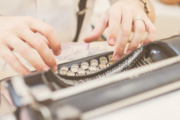 Hands writing on old typewriter
