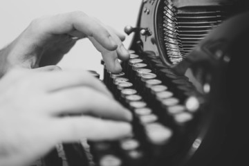 Hands writing on old typewriter