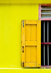 Yellow wooden door on yellow wall in old temple, Thailand