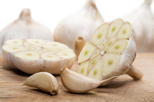 Bulbs of fresh garlic with several cloves on the cutting board.