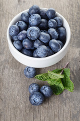 fresh blueberries in white bowl on wood table