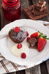 Chocolate muffin served with cream and fresh berris