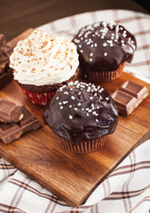 Chocolate cupcakes decorated with glaze and cream