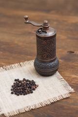 Vintage turkish pepper mill and black peppercorns