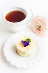Small pistachio cake with fresh violet flowers on it