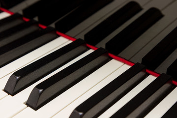 Grand piano keys with reflection in black polished finish