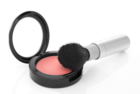 Pink blush and makeup brush on white background